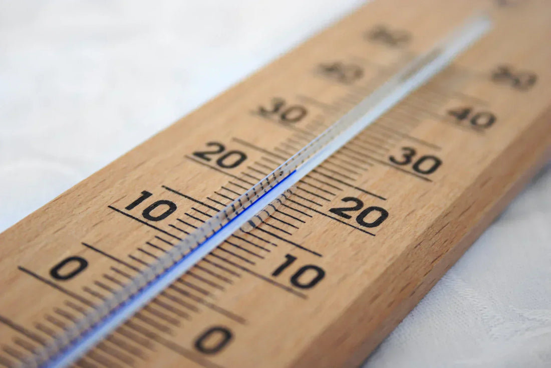 Trätermometer som visar cirka 20 grader, symbol för temperaturens påverkan på refraktometer