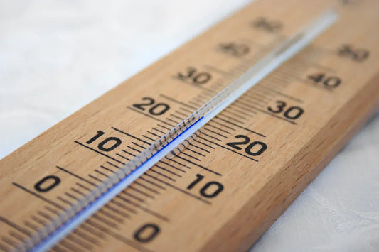 Trätermometer som visar cirka 20 grader, symbol för temperaturens påverkan på refraktometer